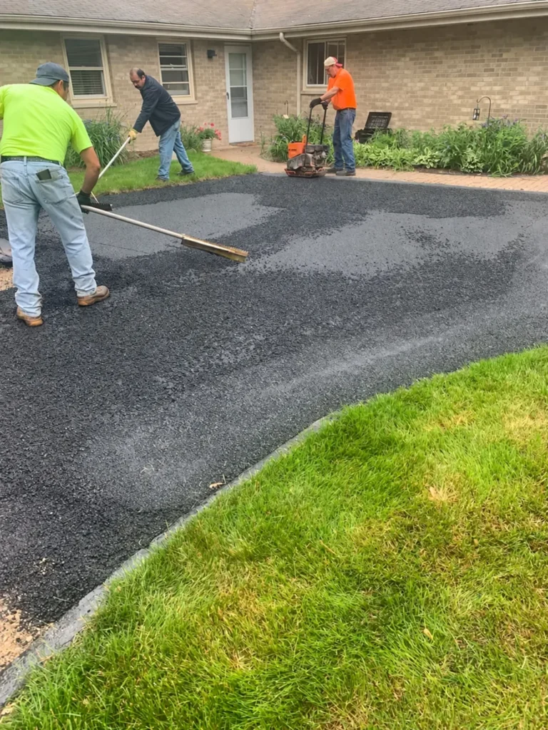 Paving crew spreading new asphalt on a driveway in Riverside South, Ottawa